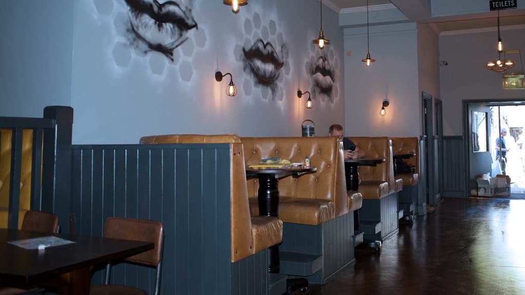 Upholstered banquette seating with a feature lip-shaped detail in a bar